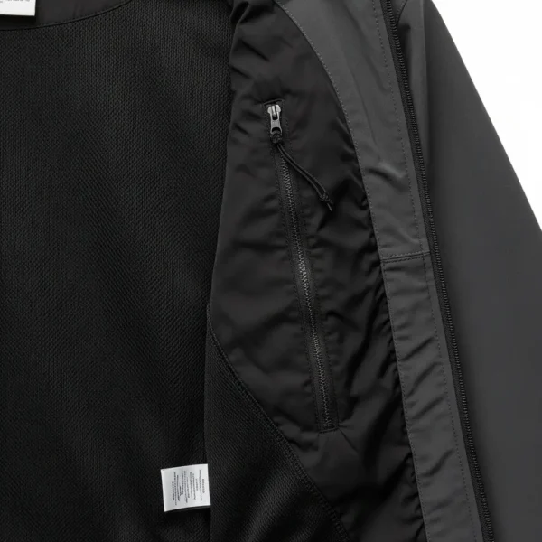 Interior view of a jacket revealing a zippered hidden pocket with a black mesh lining, ideal for secure storage of valuables.